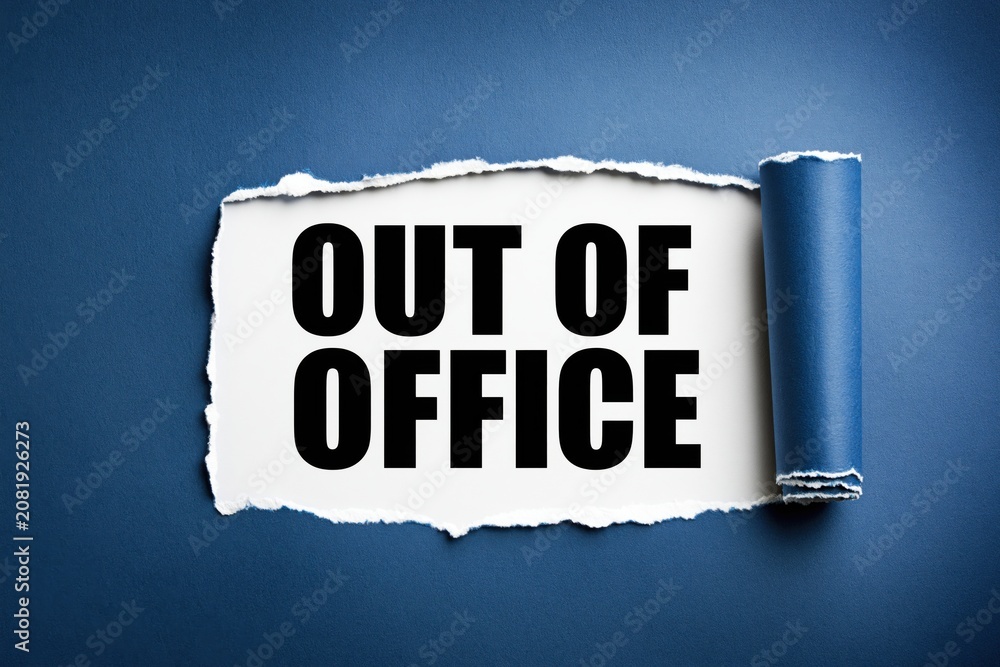 Naklejka premium Out of office phrase written on white paper under torn blue background