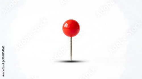 Bright red push pin standing upright on flat surface