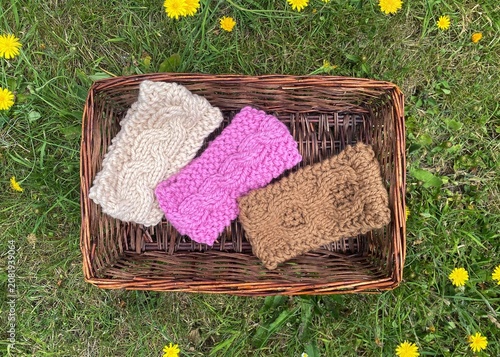 a basket of knitting, hand knit headbands with cable stitch pattern 