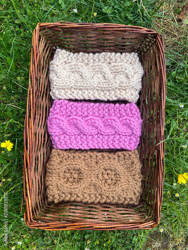 a basket of knitting, hand knit headbands with cable stitch pattern 