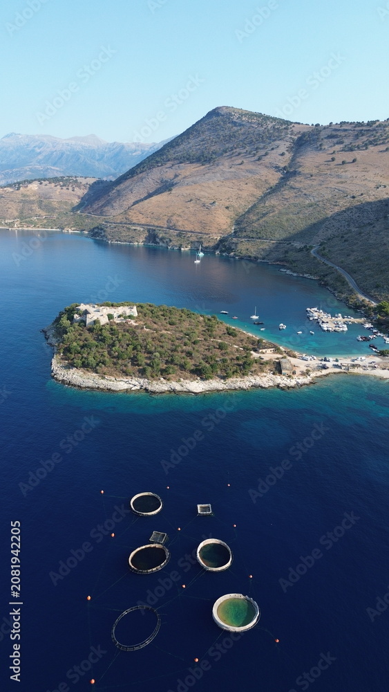 Fototapeta premium Cinematic aerial view of the historic Ali Pasha Castle on Porto Palermo peninsula surrounded by the Mediterranean Sea, Albania