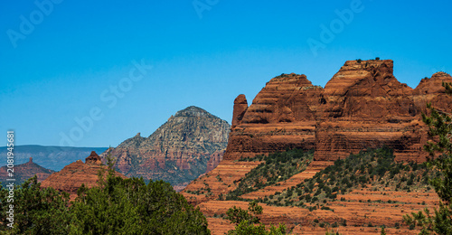 Tableau sur toile A lone column juts out of a large red sandstone formation, indication the effect
