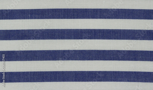 Texture of blue striped cotton cloth background. Close up of classic blue and white horizontal striped fabric.