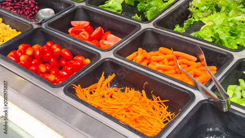 Foto Healthy salad bar buffet counter featuring fresh cherry tomatoes shredded carrot