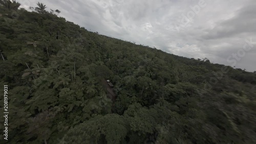 Cinematic FPV drone footage flying above the lush Ecuadorian Amazon rainforest before descending over the jungle canopy into a winding river. 