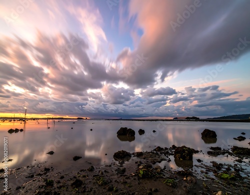 Dramatic sky reflection over coastal water at dusk wide angle