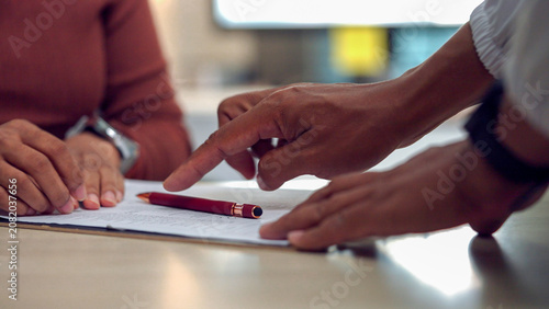 Konstfotografi Two hands point at written notes on a table