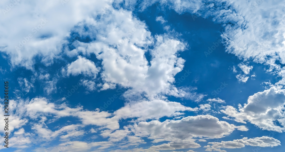 Fototapeta premium Numerous small flakes of cirrus clouds after the passage of an atmospheric front fill the sky with exquisite lace and, with detailed brushstrokes, paint magical panoramic picture. White neat feathers