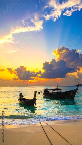 Tropical sunset beach scene with boats