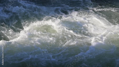 Turbulent river water flowing creating powerful rapids