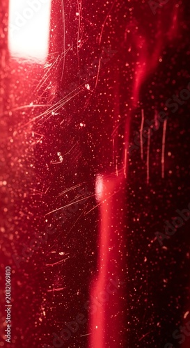 Deep Red Textured Surface with Scratches and Light Reflection.