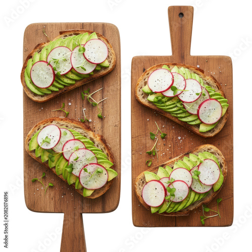 Four open-faced avocado and radish sourdough sandwiches on weathered wooden boards against a white background with microgreens concept of healthy gourmet food