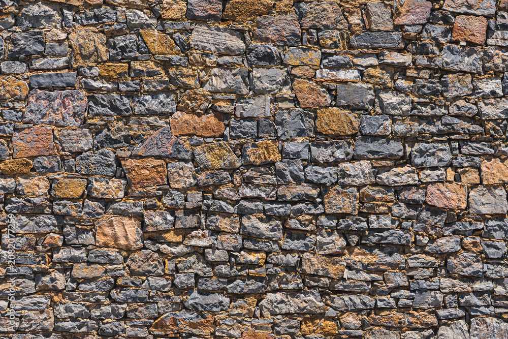 Fototapeta premium close-up of a wall built of numerous stones