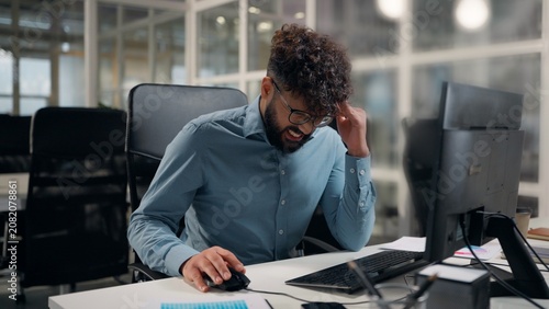 Photos Tired exhausted Arabian ethnic business man working with computer sad suffering