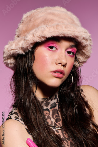 Stylish young woman showcases bold y2k fashion in studio with vibrant colors