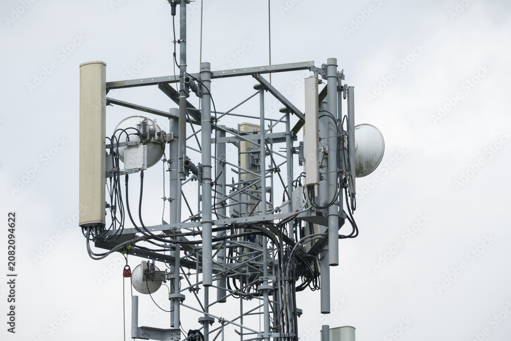 Fototapeta premium Corby, United Kingdom – July 25, 2026: Cellular communication tower with antennas and wireless network equipment, editorial