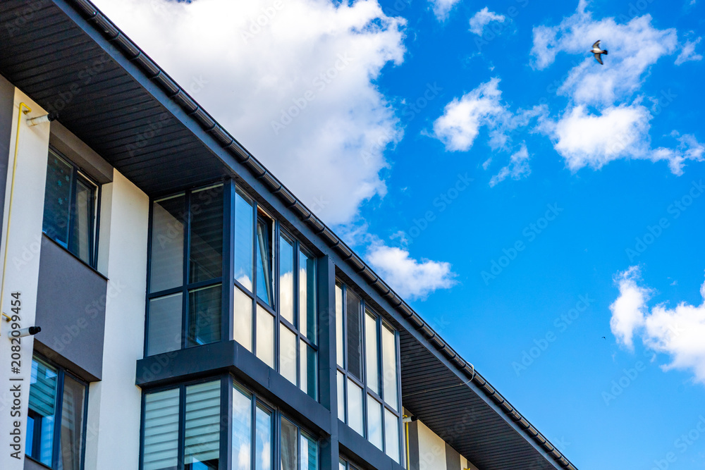 Obraz premium A building stands with large windows and a bird above it