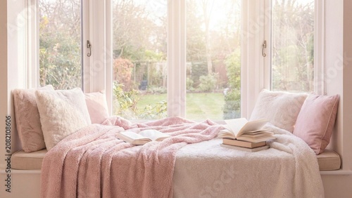 Cozy Window Seat with Books and Soft Blankets in a Bright Living Room
