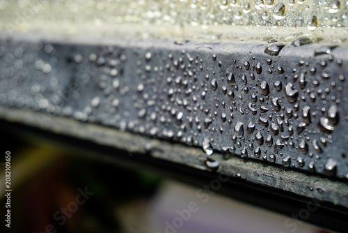 Macro shot of water droplets on a metallic surface, creating a serene and fresh atmosphere. Blurred background adds depth and highlights the texture.