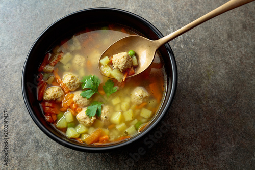 Photos Classic meatball soup with potatoes,  carrot and greens.