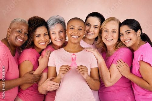 Grupo de mulheres diversas unidas em apoio à campanha Outubro Rosa segurando laço de cetim - Conceito de conscientização, prevenção e luta contra o câncer de mama.