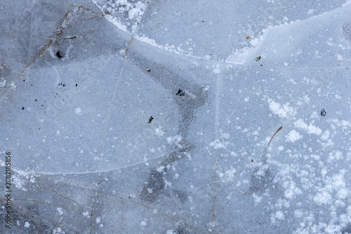 Close-up of textured ice with natural patterns and snowflakes on surface, background, texture