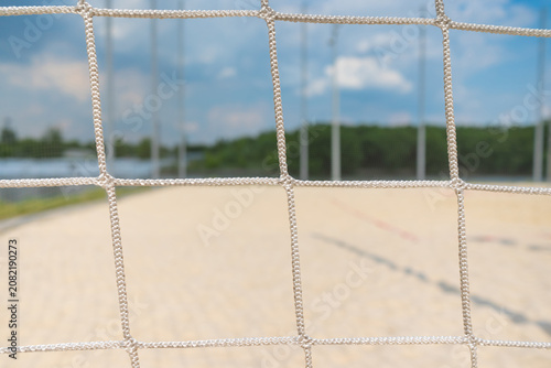 Beach volleyball net closeup on sandy beach background