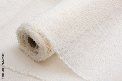 Fotografie Elegant white crinkled organza silk roll for luxury bridal gown design and sophisticated wedding fashion projects, captured in a bright studio setting for high-end textile applications