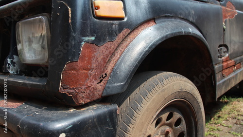 Tableau sur toile Severely corroded vehicle fender with cracked paint and exposed rust, showing metal deterioration caused by moisture, age, and environmental exposure