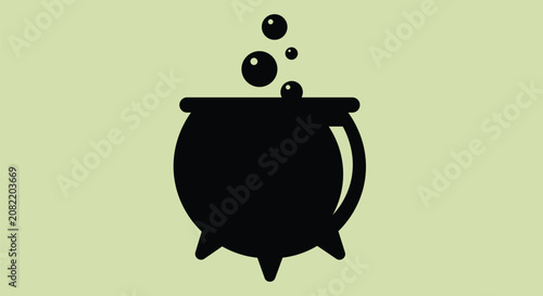 Foto Black cauldron with bubbling liquid and rising bubbles on light green background