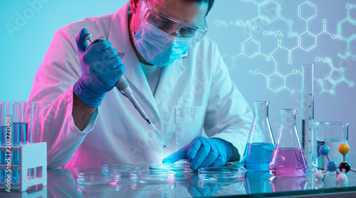 Scientist with Pipette and Colorful Flasks in Laboratory with Chemical Formulas. Science Research Concept.
