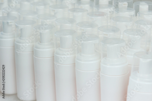 Large number of white plastic bottles. Bottles for cosmetics without labels. Cosmetics production
