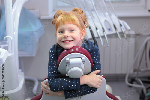 Girl is not afraid of dentist. Little girl at dentist's appointment. Girl is sitting in dental chair.
