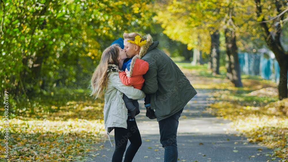 Obraz premium Family embracing, sharing tender moment among fallen golden leaves during autumn park afternoon