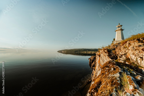 Minimalist Swedish lighthouse against golden hour sky, Lake Vattern, Sweden.