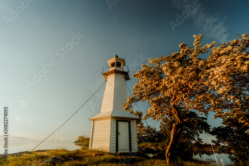 Minimalist Swedish lighthouse against golden hour sky, Lake Vattern, Sweden.