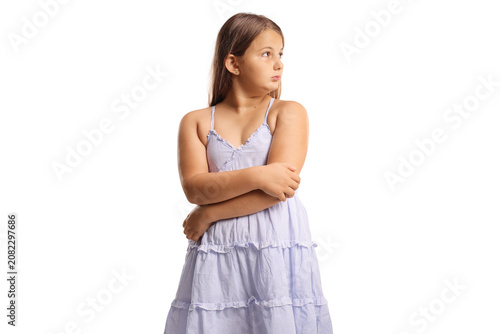 Offended child in a dress standing with arms crossed
