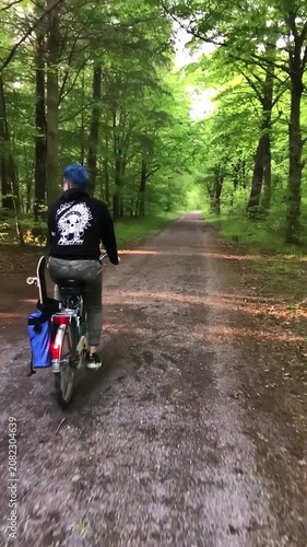 Cyclist Riding Through Forest Path on Overcast Day