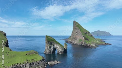Drone shot of Faroe Island cliffs with Drangarnir Sea Arch and Tindhólmur