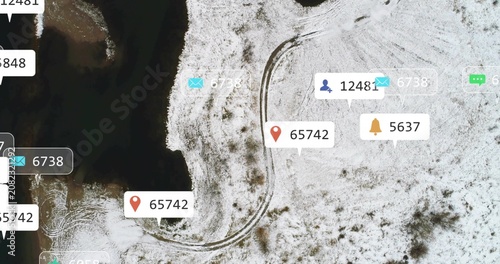 Overhead drone revealing S-curve tire tracks along shore, social media bubbles spreading over snow