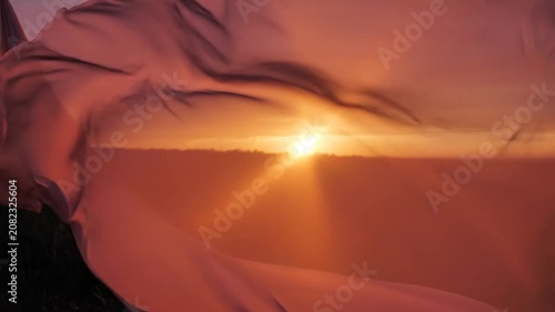 Ethereal flowing fabric against vibrant golden hour sky