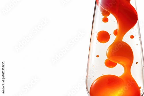 Orange liquid bubbles inside a glass container. Space for text.