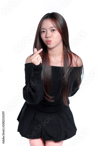 Playful Young Asian Woman Showing a Finger Heart and Pouting