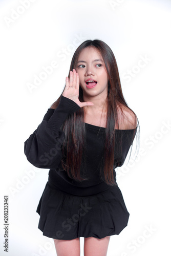 Portrait of a young Asian woman whispering or shouting a secret