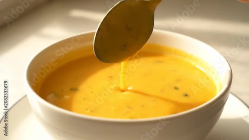 Grab a spoon to scoop soup from a bowl and scoop pumpkin puree in the sun