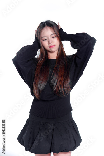 Portrait of a stressed young Asian woman holding her head in distress