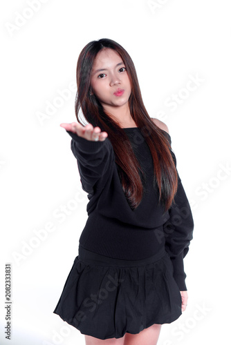 Portrait of a playful young Asian woman reaching her hand out towards the camera