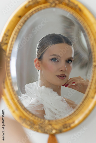 Woman reflecting on beauty and elegance in mirror