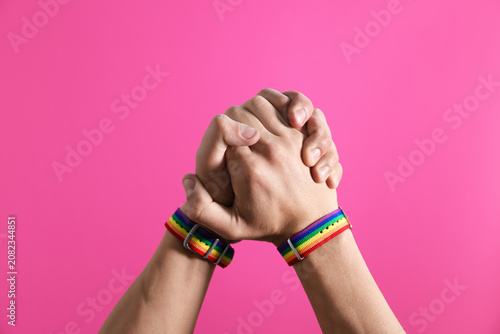 Konstfotografi LGBT. Men holding hands together on pink background, closeup