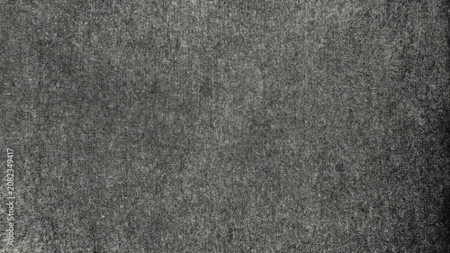 dark grey textured fabric background reveals subtle organic weave under cinematic moody overhead lighting